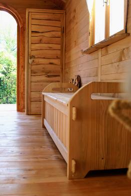 Banc coffre de la roulotte qui permet de rajouter du rangement dans le séjour.