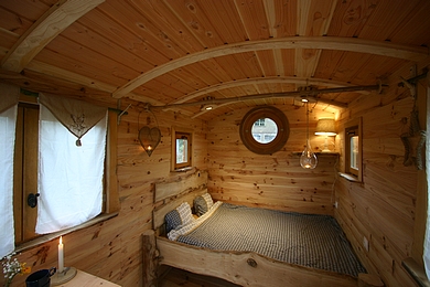 Lit en baldaquin dans la petite roulotte. 