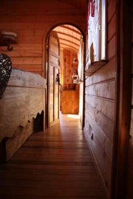 Partie chambre de la roulotte avec le lit artisanal et le tiroir en dessous.