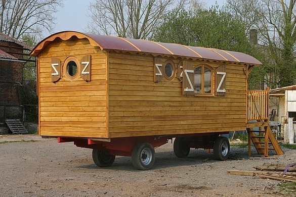 Petite roulotte aménagée avec la terrasse sur le devant.