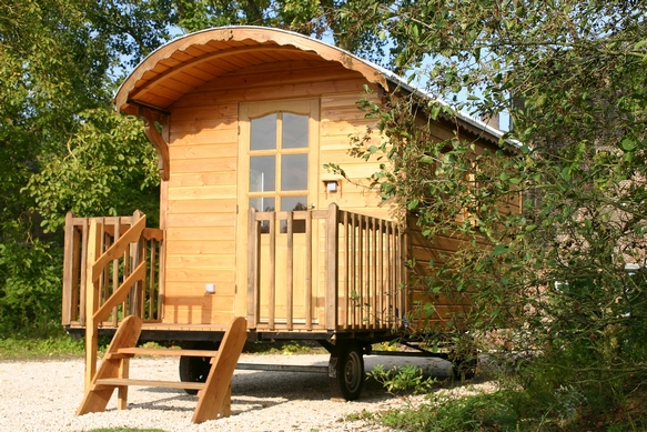 Roulotte pouvant être transportée sur une remorque.