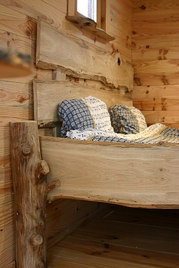 Lit artisanale de la roulotte en rondin.