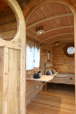 Entrée de la roulotte avec la porte artisanale en demie ronde