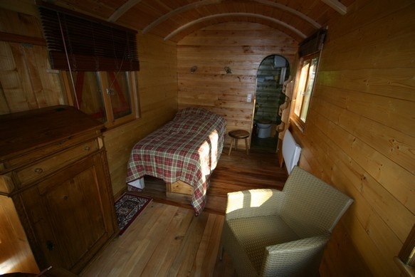 Intérieur de la roulotte avec séjour et la chambre qui communique.